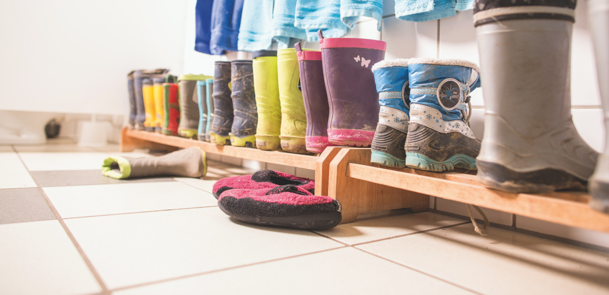 Fotoaufnahmen im Kinderhaus Melle-Buer. Kleine Handtücher und Gummistiefel aufgereiht.
Coverfoto der Broschüre Qualitätsausbau in KiTas 2016, 7 Fragen zur Personalausstattung in deutschen KiTas, 7 Antworten der Bertelsmann Stiftung.